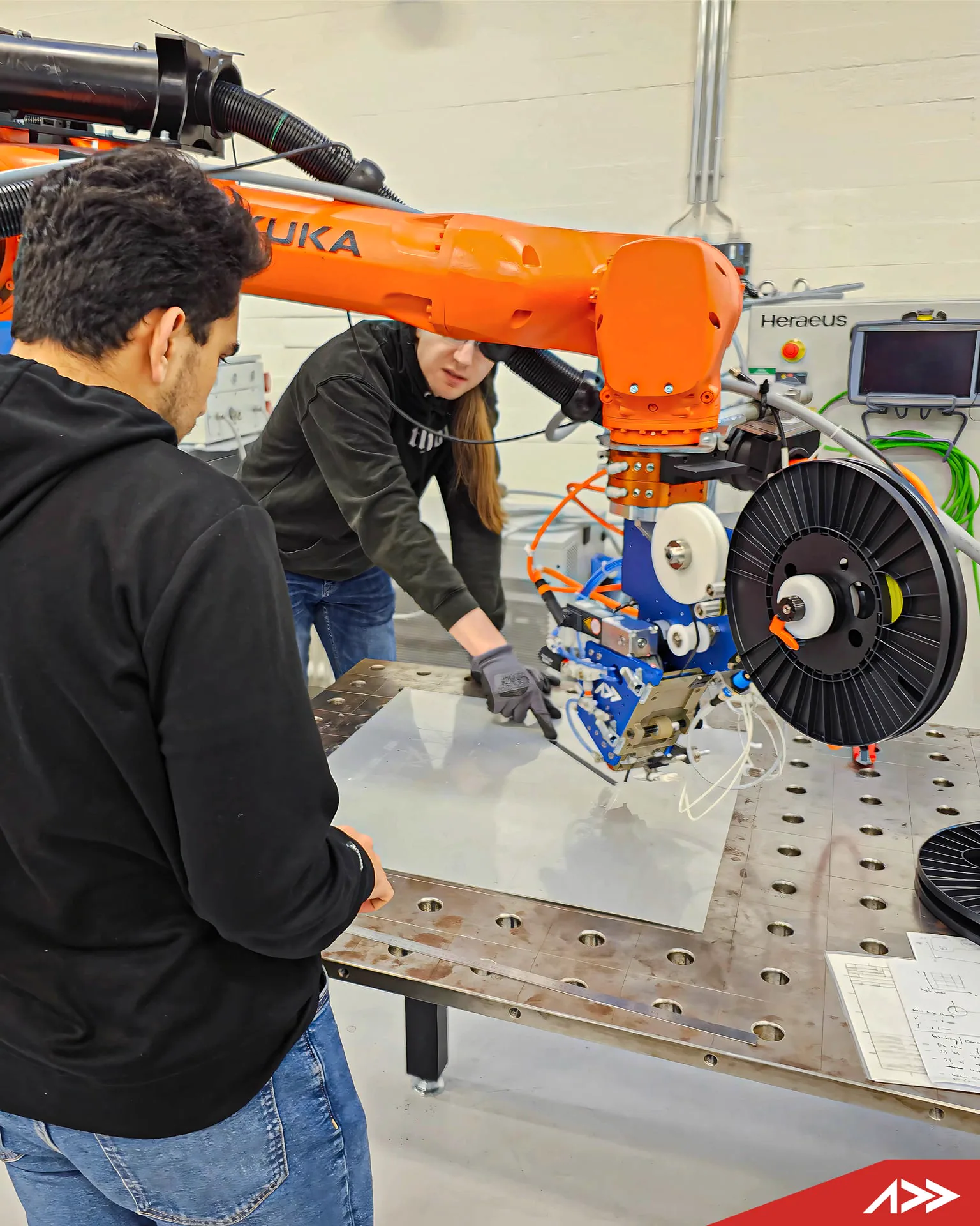Engineers integrating an Addcomposites system with an industrial robot